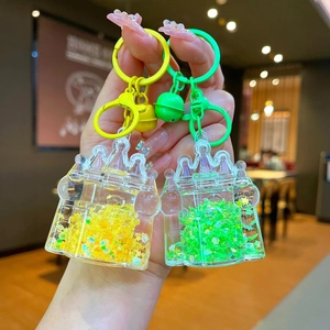 Luminous castle oil keychain with glitter quicksand in yellow and green colors