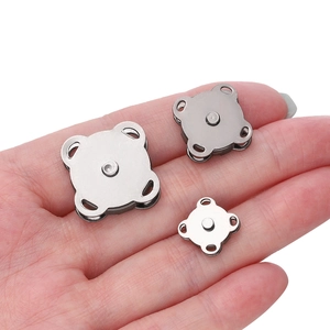 Three sizes of silver metal magnetic snaps shown on palm for direct size comparison