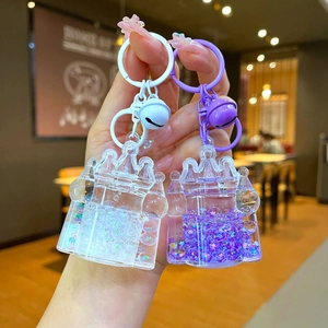 Detail of castle-shaped liquid glitter keychains with bells and star sequins