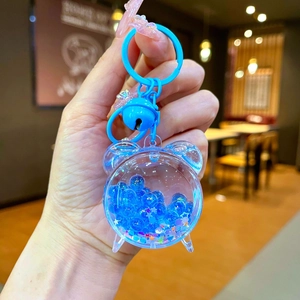 Blue acrylic alarm clock liquid sand keychain with colorful star sequins and small bell