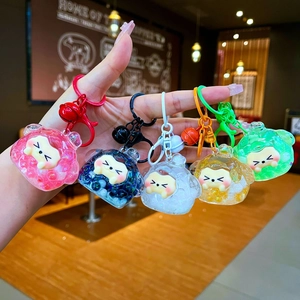 Close-up of five colorful mini sheep keychains with liquid sand glitter and small bells