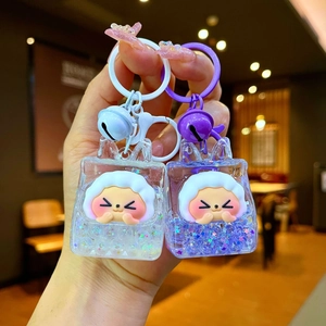 Detail of creative liquid sand keychains featuring cartoon figures in mini bags