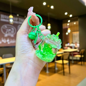 Close-up of green iceberg cup keychain with liquid glitter and a small bell