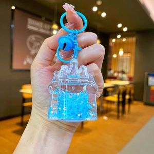Detail of blue liquid sand castle keychain with floating glitters and star sequins