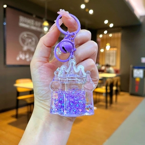 Detail of purple castle keychain with flowing liquid, star glitter, and matching bell