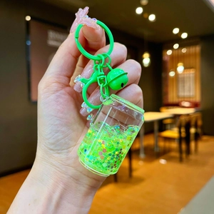 Detail of green liquid quicksand keychain with star sequins and matching metal bell
