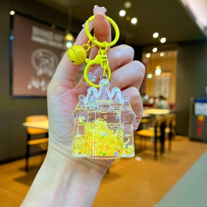 Close-up of yellow castle liquid glitter keychain with bell and ring attachment