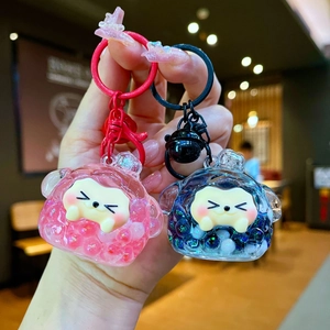 Close-up of cute cartoon milk bean keychains with colorful flowing beads inside