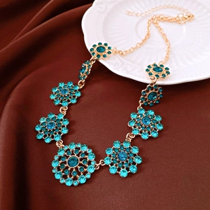 Detailed view of a vintage palace style necklace with turquoise crystal rhinestones in gold