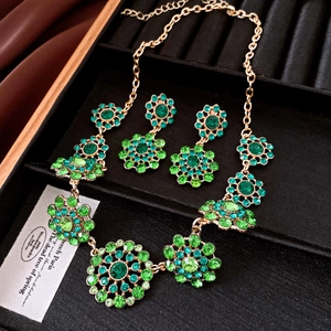 Close-up of vintage emerald green floral crystal necklace and earrings jewelry set