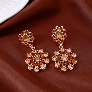 Macro detail of vintage palace style drop earrings with red and champagne crystals