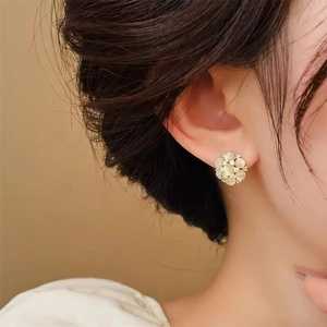 Gros plan sur d'élégantes boucles d'oreilles en forme de fleur avec œil-de-chat et zircons