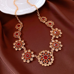 Close-up detail of a luxury vintage court style necklace with red and champagne crystals