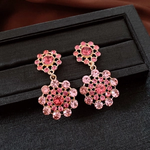 Macro view of vintage palace style floral drop earrings encrusted with pink rhinestones