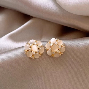 Vue détaillée de boucles d'oreilles fleurs élégantes avec pierres œil de chat et zircons