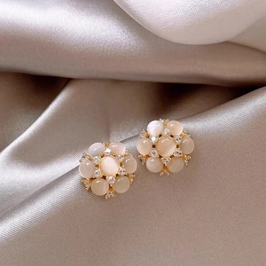Vue macro de boucles d'oreilles œil-de-chat florales avec accents de zircon brillant.