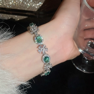 Nahaufnahme des eleganten Armbands mit smaragdgrünen Zirkonia-Blumen am Handgelenk