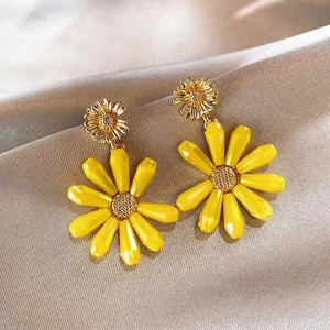 Detailed macro view of yellow daisy flower stud earrings with golden metallic centers.
