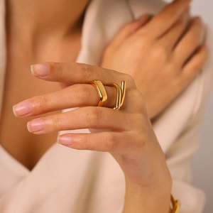Elegant close-up of a gold-plated cross-line titanium steel ring with a small diamond detail