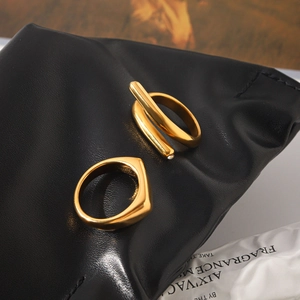Detailed macro shot of gold-plated titanium steel rings featuring a criss-cross design.
