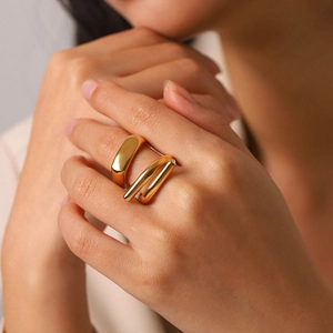 Close-up of a minimalist gold-plated titanium steel ring with a wrap-around cross line design