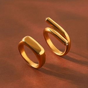 Detailed close-up of gold plated titanium steel minimalist signet and spiral wrap rings