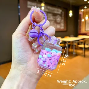 Macro shot of purple liquid sand keychain with glitters, showing dimensions 5cm x 3.5cm