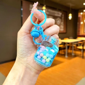 Close-up of a blue liquid quicksand keychain with gas tank shape and colorful beads