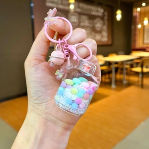 Macro view of pink charm keychain with colorful beads inside a transparent bottle charm