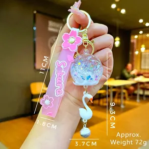 Portachiavi Sakura con glitter liquidi, ciondolo a cigno e campanellino argentato