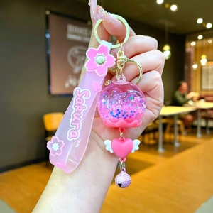 Dettaglio ravvicinato del portachiavi Sakura rosa con paillettes e ciondoli a stella