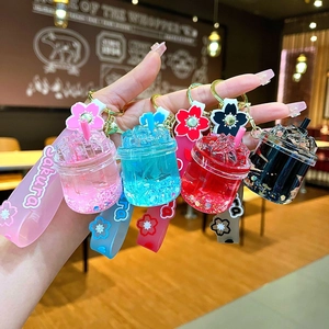 Close-up of liquid filled acrylic cup keychains with Sakura wristbands and floral charms