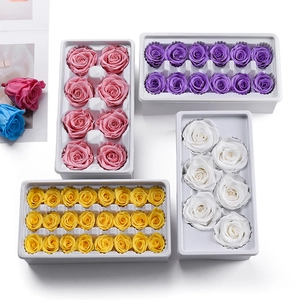 Preserved eternal roses set in multiple colors like pink and purple on white trays