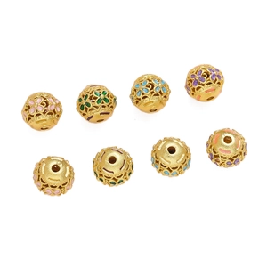 Macro-opname van gouden holle kralen met kleurrijk emaille en Fu-teken voor doe-het-zelf sieraden