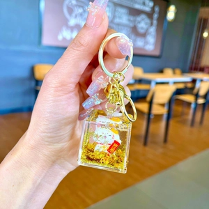 Macro view of Maneki Neko lucky cat liquid glitter keychain with golden metal ring