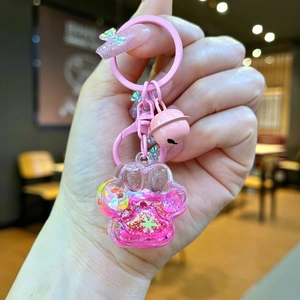 Gros plan d'un porte-clés patte de chat rose avec paillettes liquides et clochette