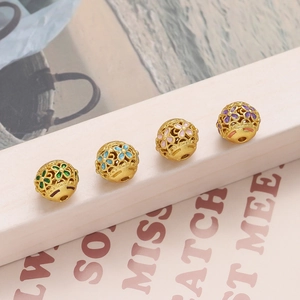 Macro detail van holle koperen gouden kralen met kleurrijke emaille bloemen voor sieraden
