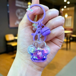 Détail du porte-clés patte de chat violet avec paillettes mouvantes et petit grelot