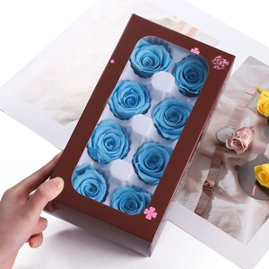 Detail of 8 blue preserved roses in a brown window gift box with elegant floral patterns
