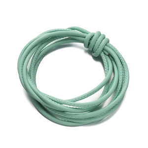 Detail of mint green braided faux leather cord with refined stitching for DIY jewelry
