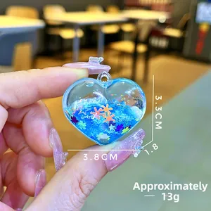 Detailed view showing dimensions 3.8x3.3cm of a heart-shaped blue quicksand keychain