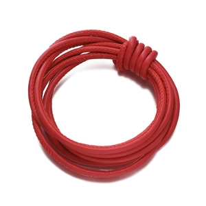 Close-up of red braided PU leather cord with intricate knot detail and precision stitching