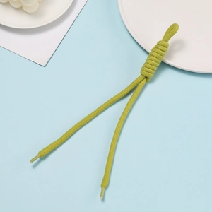 Close-up of grass green braided phone strap with handcrafted knot and clear plastic ends