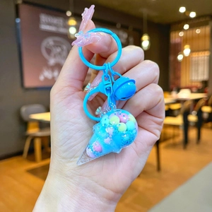 Close-up of cute blue ice cream keychain with liquid sand, bell, and metal ring charm