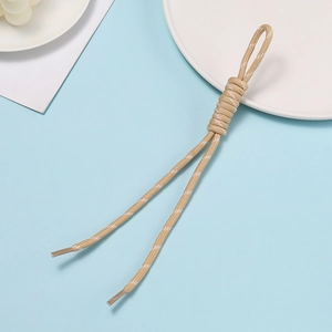 Close-up of khaki braided lanyard cord with white dot pattern and clear plastic tips