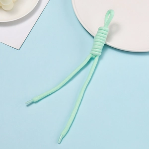 Close-up of mint green braided cord with durable plastic tips on a blue background