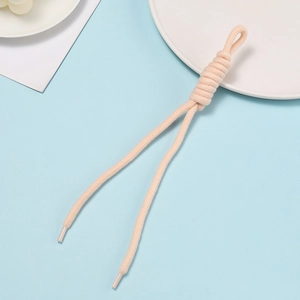 Detail of pink hand-woven cord with decorative knot and plastic sealed ends