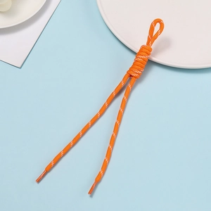 Macro shot of bright orange woven polyester lanyard with spiral knotting and plastic tips