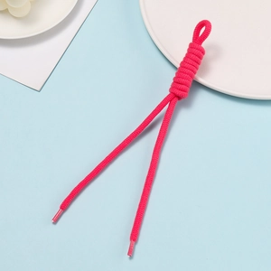Close-up of rose red hand-woven rope with knots and plastic tips for bags and phones