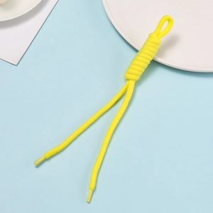 Macro shot of bright yellow braided rope with decorative spiral knots and transparent tips